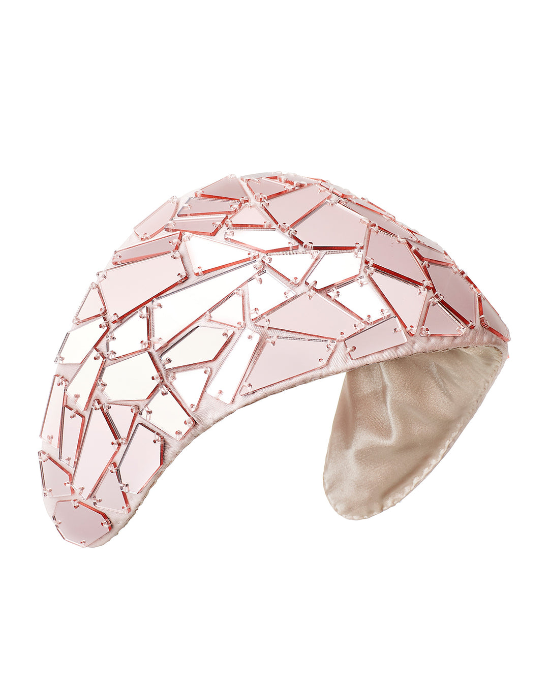 Blush-toned structured half-hat embellished with geometric mirrored panels in soft rose and clear finishes, arranged in a mosaic pattern and lined with smooth champagne satin. Designed and made by Merve Bayindir Millinery.
