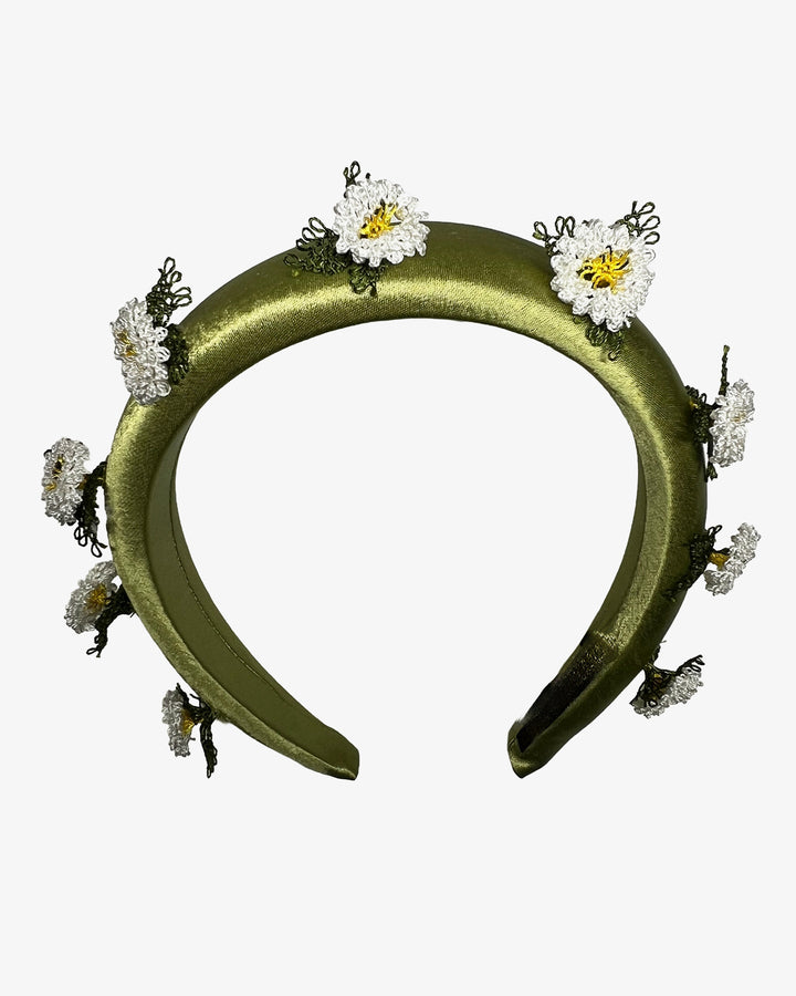 Olive green satin padded headband embellished with small hand embroidered white daisy flowers featuring yellow centres and delicate green thread leaves spaced around the band. Designed and made by Merve Bayindir Millinery.

