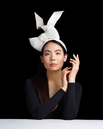 The model is wearing a sateen contemporary headband with a large buntal bow and flying thick buntal ribbons.