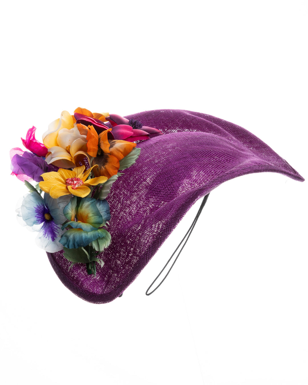 Purple sinamay sculpted fascinator with a curved, wave-like shape, adorned with a vibrant cluster of multicolored flowers and mounted on a slim black headband. Designed and made by Merve Bayindir Millinery.

