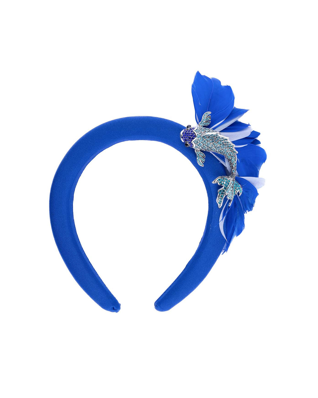 Still life picture of cobalt blue high headband showcases a metal koi fish decorated with blue shades of crystals adorned with feathers behind it to create the illusion of a wave. The luxury headband is a contemporary statement. Made by Merve Bayindir Millinery.