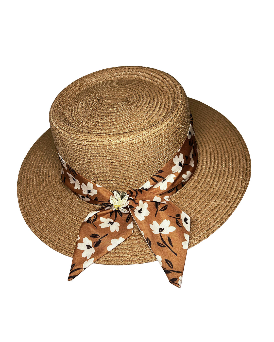Natural woven straw boater hat with a wide brim, adorned with a brown floral-print ribbon tied in a bow and finished with a small embroidered flower detail at the center. Designed and made by Merve Bayindir millinery.