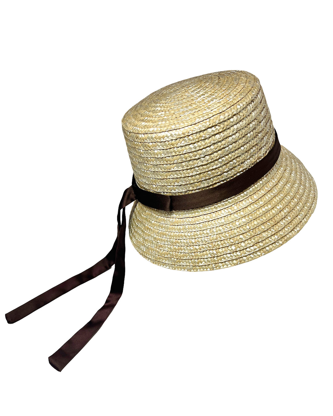 Natural woven straw bucket hat with a softly sloping brim, finished with a brown ribbon band and long trailing ties at the side. Designed and Made by Merve Bayindir millinery. Designed and made by Merve Bayindir millinery.