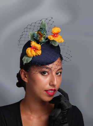 Model is wearing a button shape fascinator with flower decorations