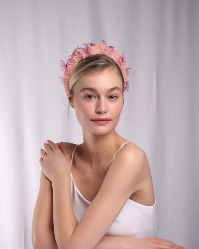 The model is wearing a peach coloured beads on a headband adorned with pink organza butterflies.