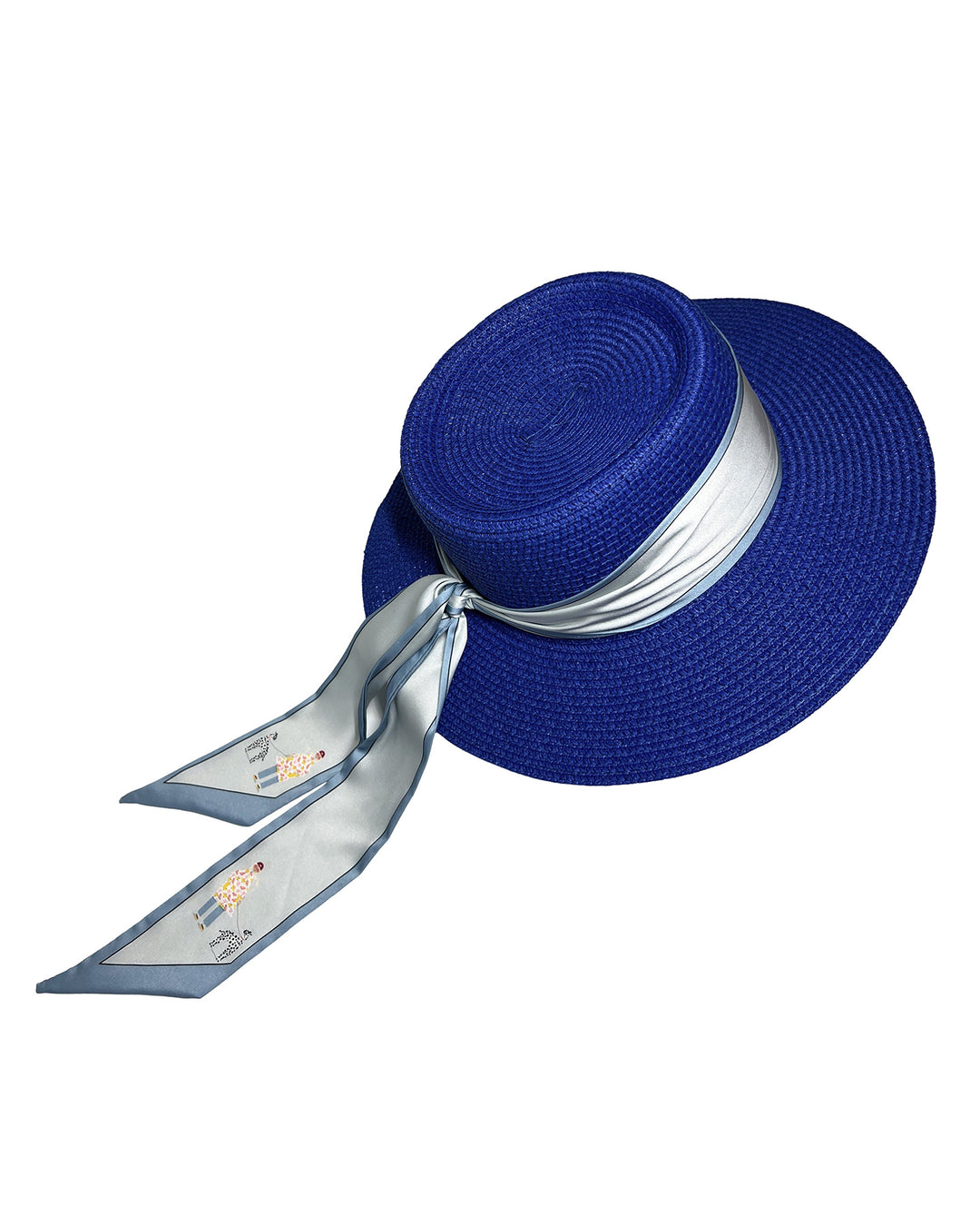 Royal blue woven straw boater hat with a wide brim, wrapped in a soft pale grey silk ribbon and finished with long scarf ties featuring delicate illustrated figures. Designed and made by Merve Bayindir millinery.
