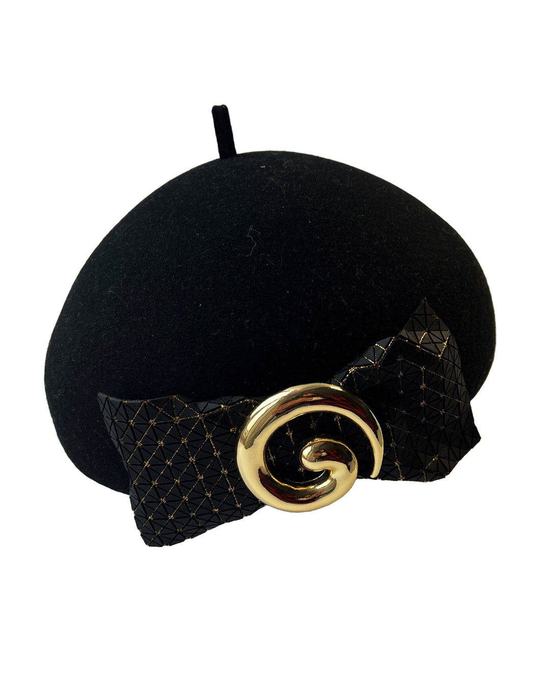 Still life picture of the black dome-shaped, round-structured Clarisse wool felt pillbox beret. This is an embellished, textured piece with a gold metallic-based black faux leather bow tied in the centre, featuring a sculpted gold spiral. Designed by Merve Bayindir.