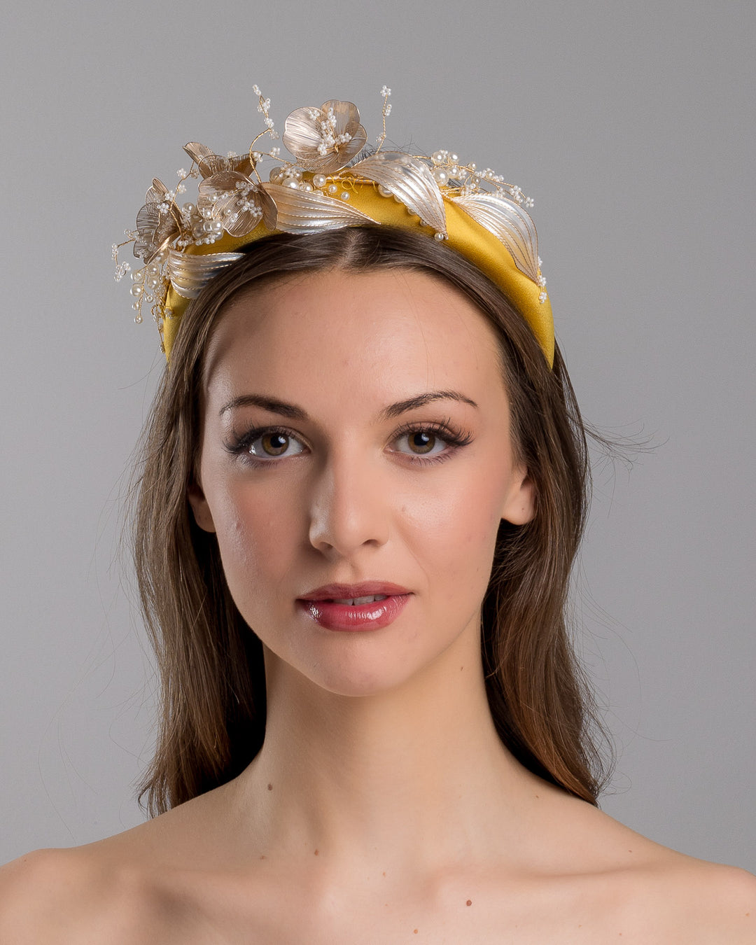 Model is showcasing the front of the yellow satin headband decorated with bead flowers , resin flowers and leaves with golden wires. Made by Merve Bayindir.