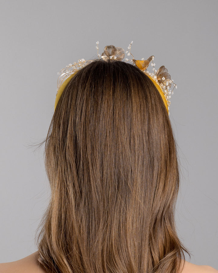 Model is showcasing the back of the yellow satin headband decorated with bead flowers , resin flowers and leaves with golden wires. Made by Merve Bayindir.