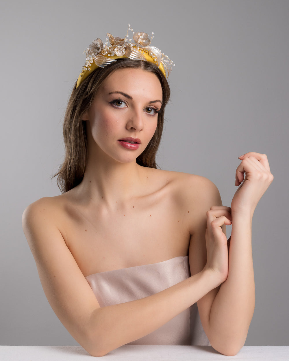 Model is posing wearing mustard yellow satin headband decorated with bead flowers , resin flowers and leaves with golden wires. Made by Merve Bayindir.