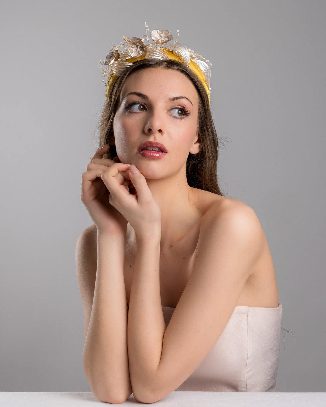 Model is posing wearing mustard yellow satin headband decorated with bead flowers , resin flowers and leaves with golden wires. Made by Merve Bayindir.