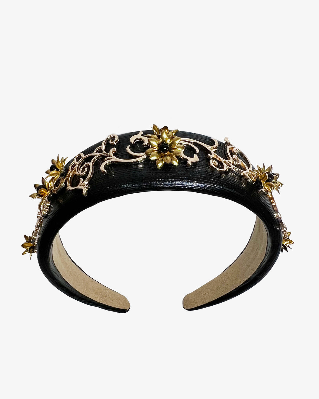Wide black satin headband embellished with ornate gold filigree scrollwork and small metallic floral accents, creating a regal, baroque-inspired statement design.
Designed and made by Merve Bayindir Millinery.

