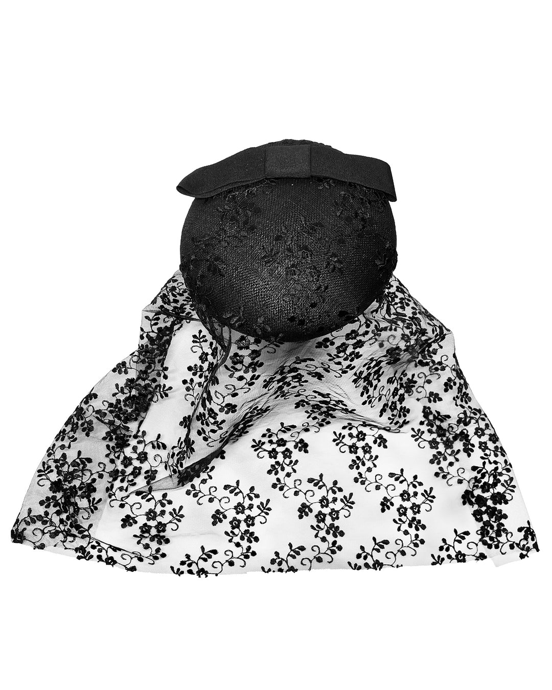Black round hat with a structured crown and subtle floral texture, topped with a wide ribbon band and finished with a long sheer lace veil embroidered with delicate black floral patterns. Designed and made by Merve Bayindir Millinery.