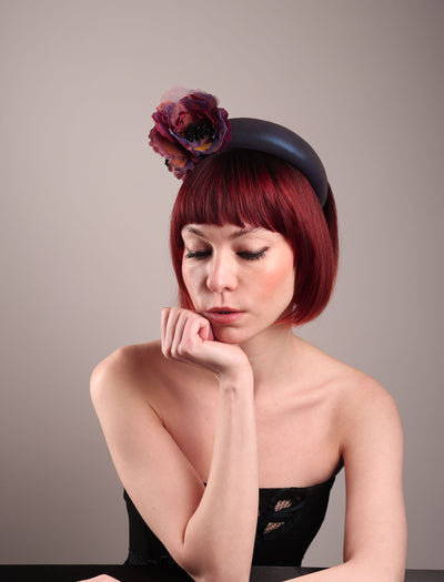 Model wearing and showcasing the right front side of an iridescent Eclipse Headband with layered flower detail in deep purple, bronze, and wine tones, handcrafted by Merve Bayindir.
