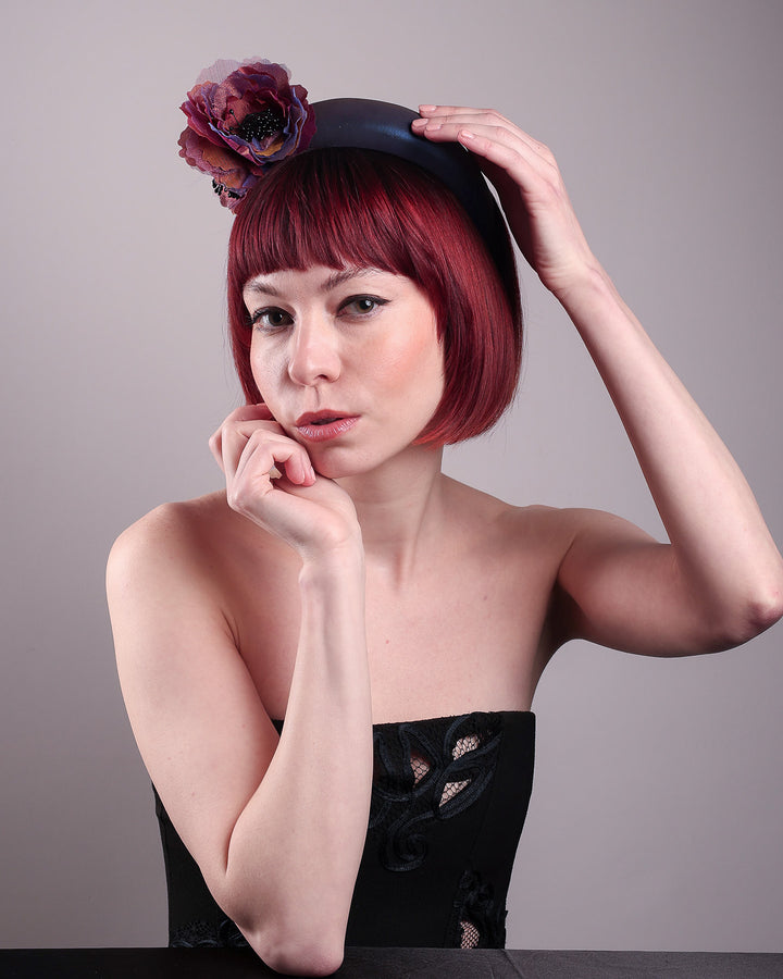 Model wearing and showcasing the right angle of an iridescent Eclipse Headband with layered flower detail in deep purple, bronze, and wine tones, handcrafted by Merve Bayindir.
