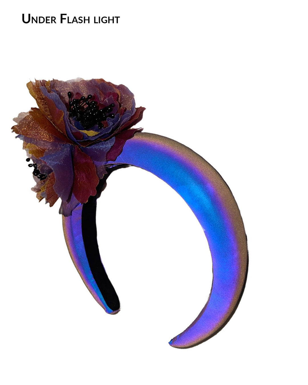 Product shout of Eclipse Headband in flash lightining, glowing in shades of blue, violet, and bronze with padded band with handcrafted mulberry and bronze flower, couture headband by Merve Bayindir.