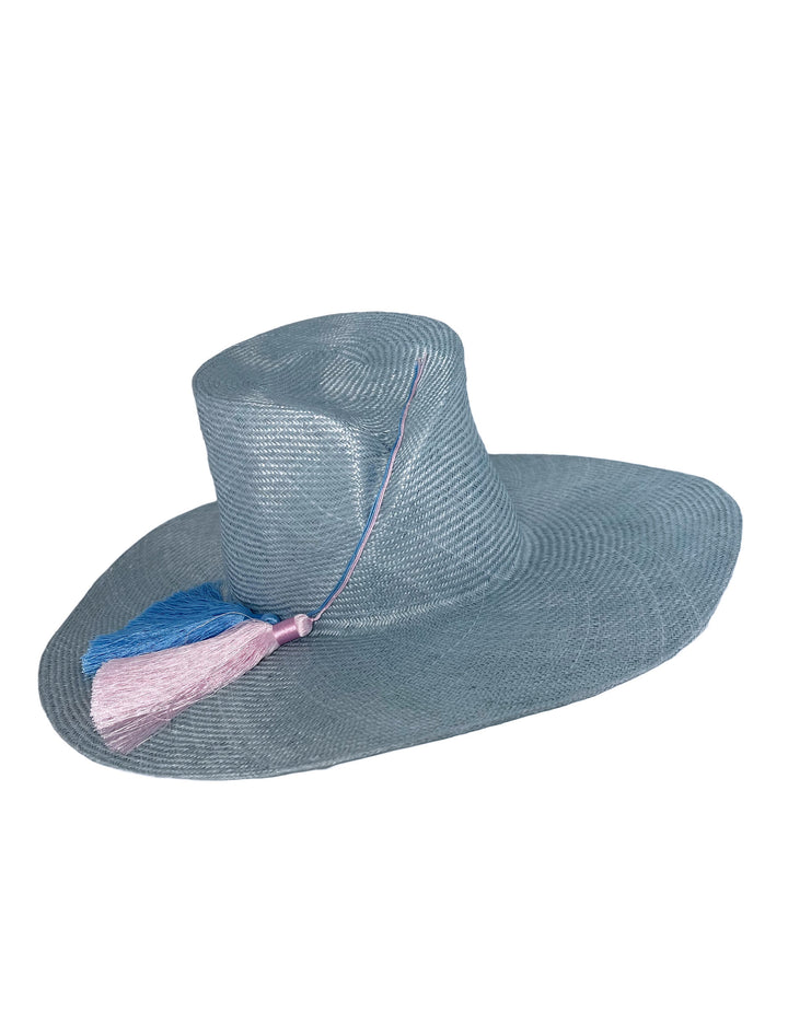 Blue straw hat with a pink tassel on a white background