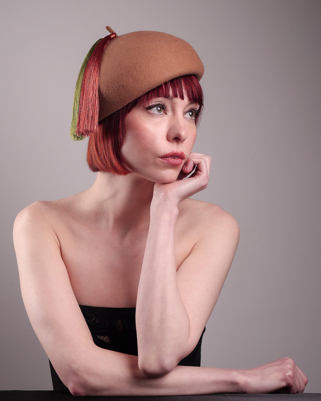 The model is showcasing the front right side from the below angle of the Faye Beret Hat, handcrafted in camel wool felt. It&