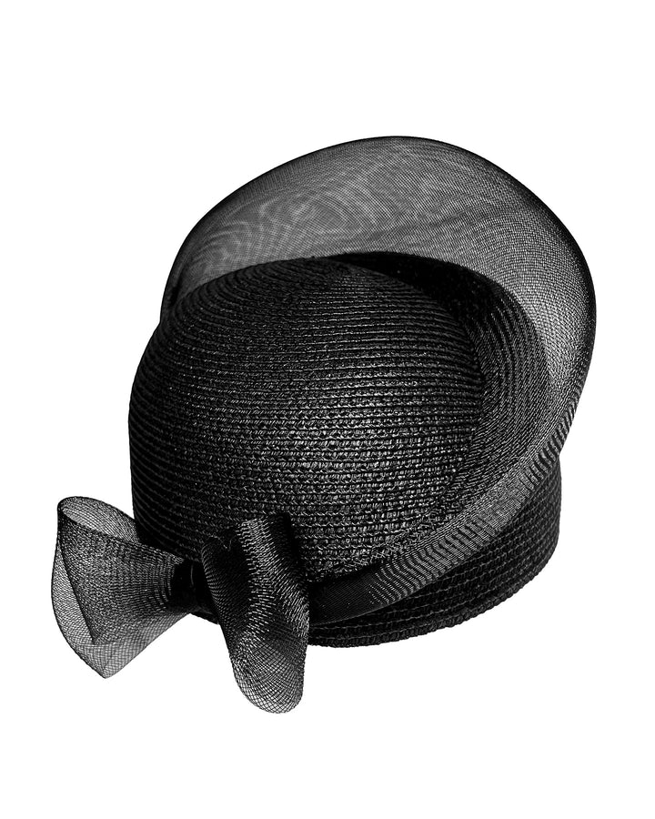 Black straw pillbox hat with a structured woven crown, wrapped in a sheer sinamay band that curves around the top, finished with a delicate mesh bow detail at the side.Designed and made by Merve Bayindir Millinery.
