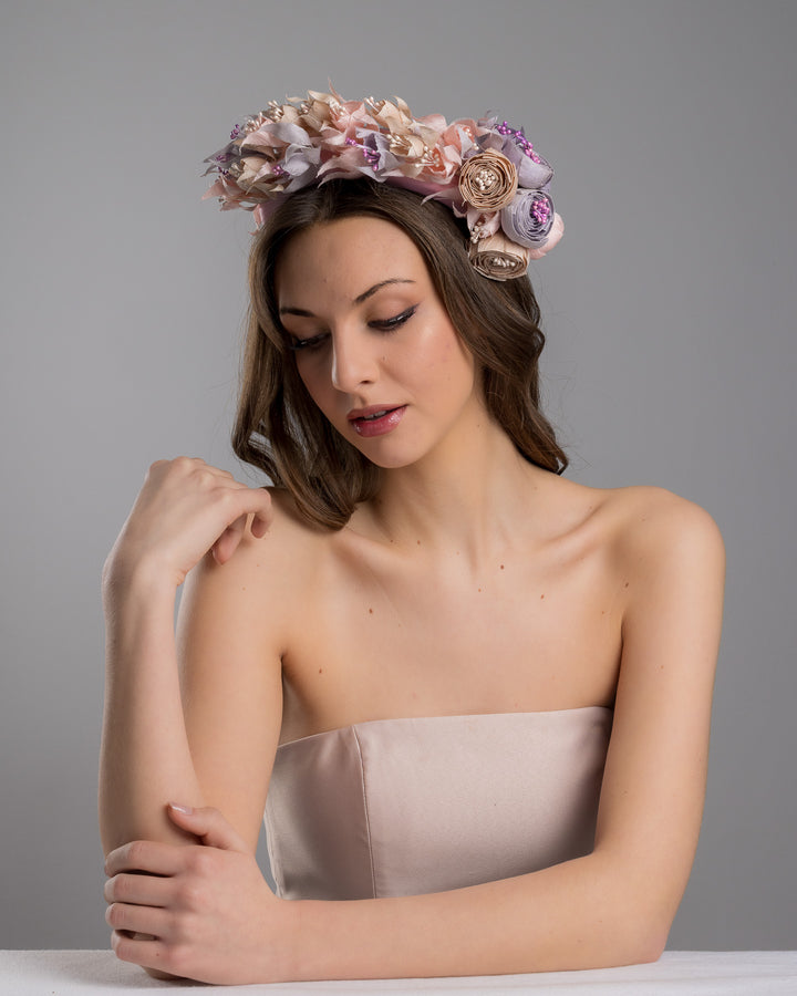 Model is posing wearing Flamenco a high pink headband decorated with custom made silk taffeta lilac, pink and ecru bouquet of peony and fuchsia flowers. Made by Merve Bayindir.