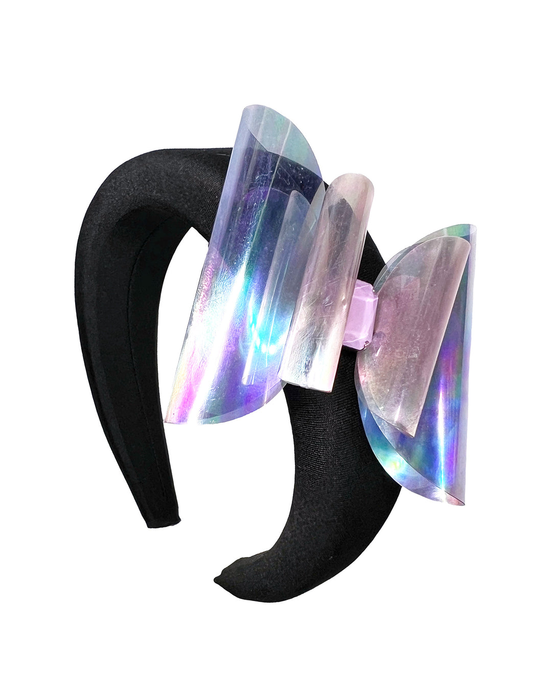 Black padded headband featuring an oversized sculptural bow made from iridescent translucent panels with a holographic sheen, accented at the center with a soft pink geometric embellishment.
Designed and made by Merve Bayindir Millinery.
