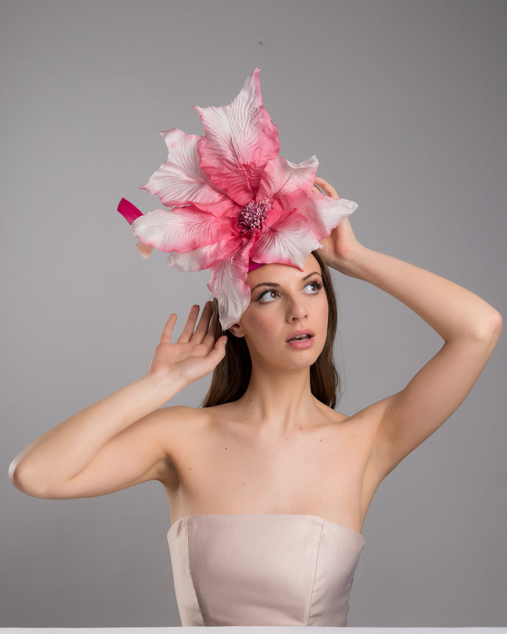 The female model is posing, wearing
Ischia, the button shape Sinamay base decorated with custom made large silk chiffon flower and Jinsin swirls. Fitted with a wire headband and comb. Designed and made by Merve Bayindir Millinery.
