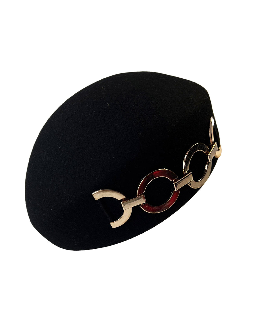 The still life picture of the Liora black wool felt beret, which features a geometric gold-tone chain embellishment that arches across the crown. Designed by Merve Bayindir.