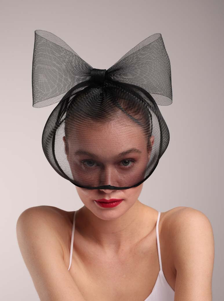 Model is wearing a custom made crin mask with a large bow on it