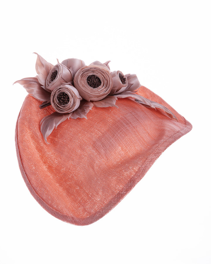 Coral sinamay fascinator with a softly sculpted asymmetrical base, topped with blush-toned handcrafted rosette flowers and delicate matching leaves, mounted on a slim headband. Designed and made by Merve Bayindir Millinery.
