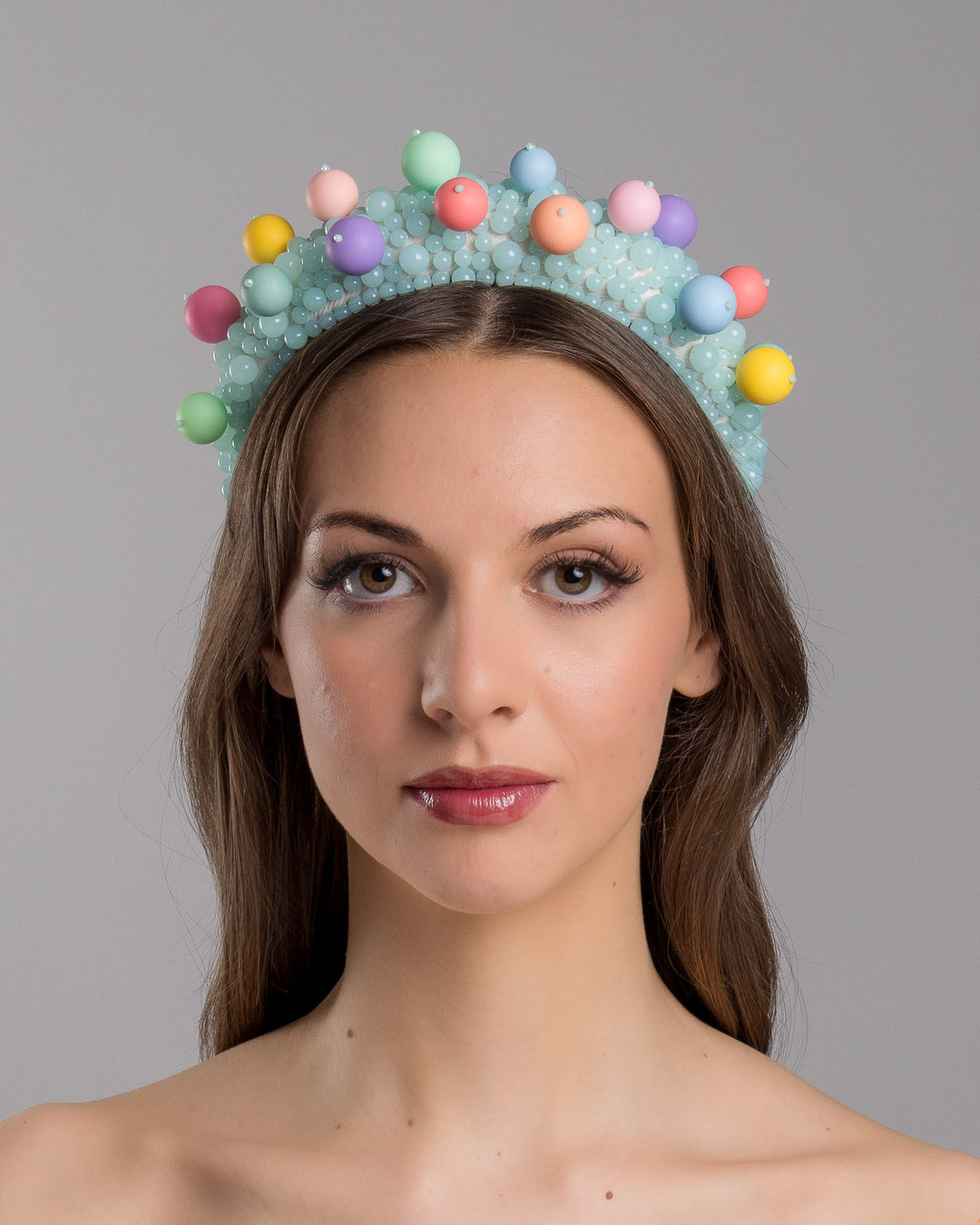 Model is showcasing the front side close up of multi size mint coloured beaded headband adorned with large multi size mat bubble look a like multi colour multi size beads. Made by Merve Bayindir.