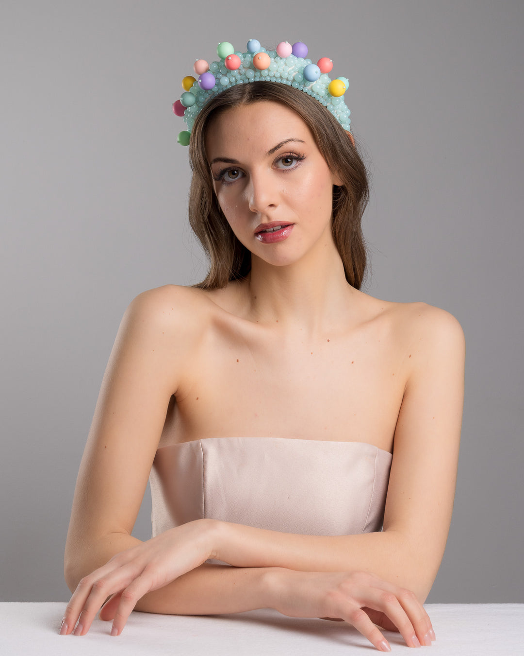 Female model posing wearing multi size mint coloured beaded headband adorned with large multi size mat bubble look a like multi colour multi size beads. Made by Merve Bayindir.