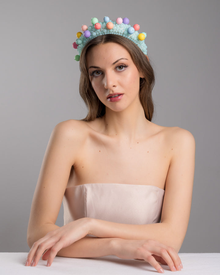 Female model posing wearing multi size mint coloured beaded headband adorned with large multi size mat bubble look a like multi colour multi size beads. Made by Merve Bayindir.