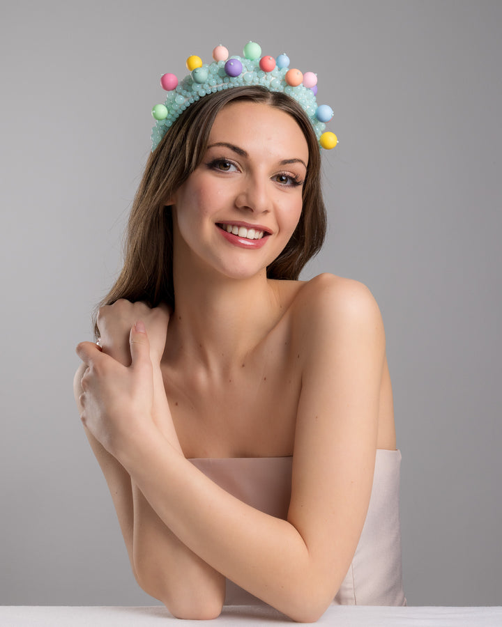 Female model posing wearing multi size mint coloured beaded headband adorned with large multi size mat bubble look a like multi colour multi size beads. Made by Merve Bayindir.