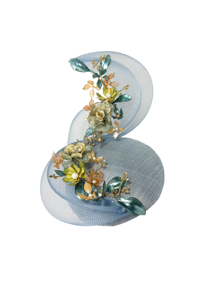 Light blue fascinator with floral decorations on a white background