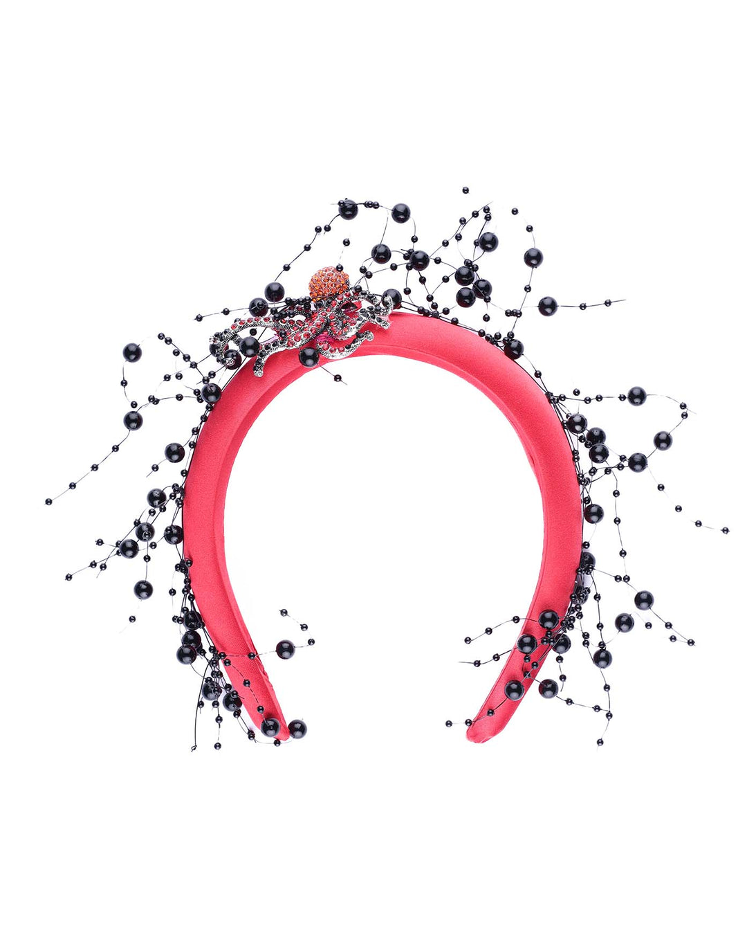 Still life picture of bright red silk sateen headband, decorated with crystal embellish octopus brooch and multi size black loose beads. Made by Merve Bayindir Millinery.
