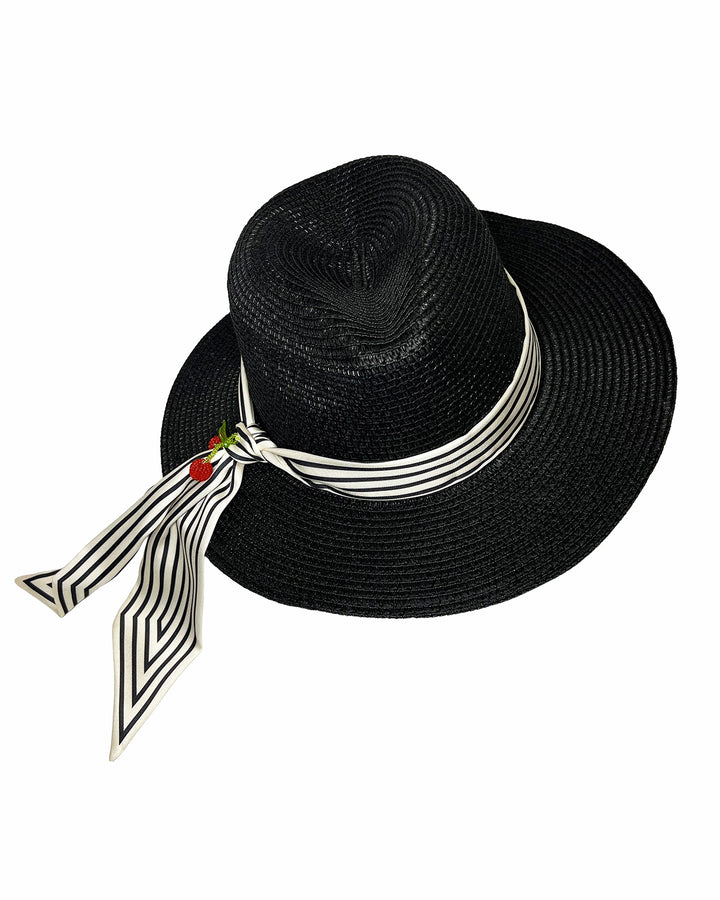 Black woven straw boater hat with a wide brim, wrapped in a black and white striped ribbon and finished with long scarf ties accented by small red cherry embellishments. Designed and Made by Merve Bayindir millinery.