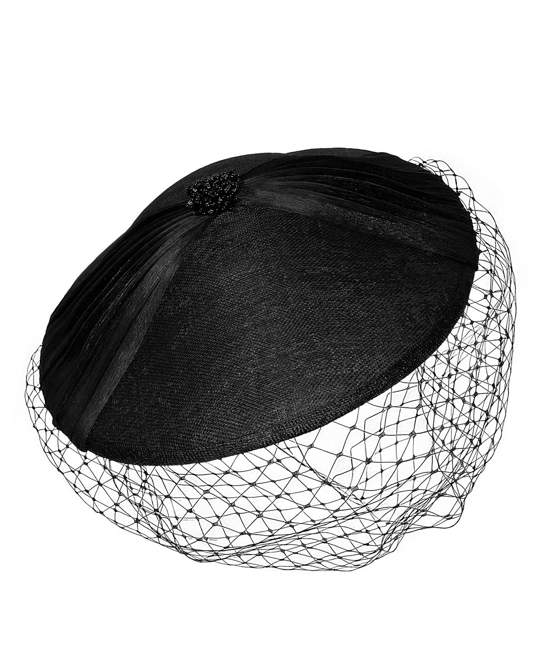 Black oval fascinator crafted from fine sinamay, featuring soft pleated detailing across the crown, a small beaded accent at the top, and a delicate birdcage veil that drapes over the face. Designed and made by Merve Bayindir Millinery.
