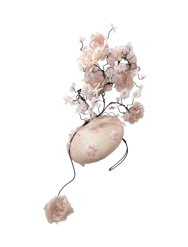 Decorative headpiece with pink flowers and a large beige stone on a white background
