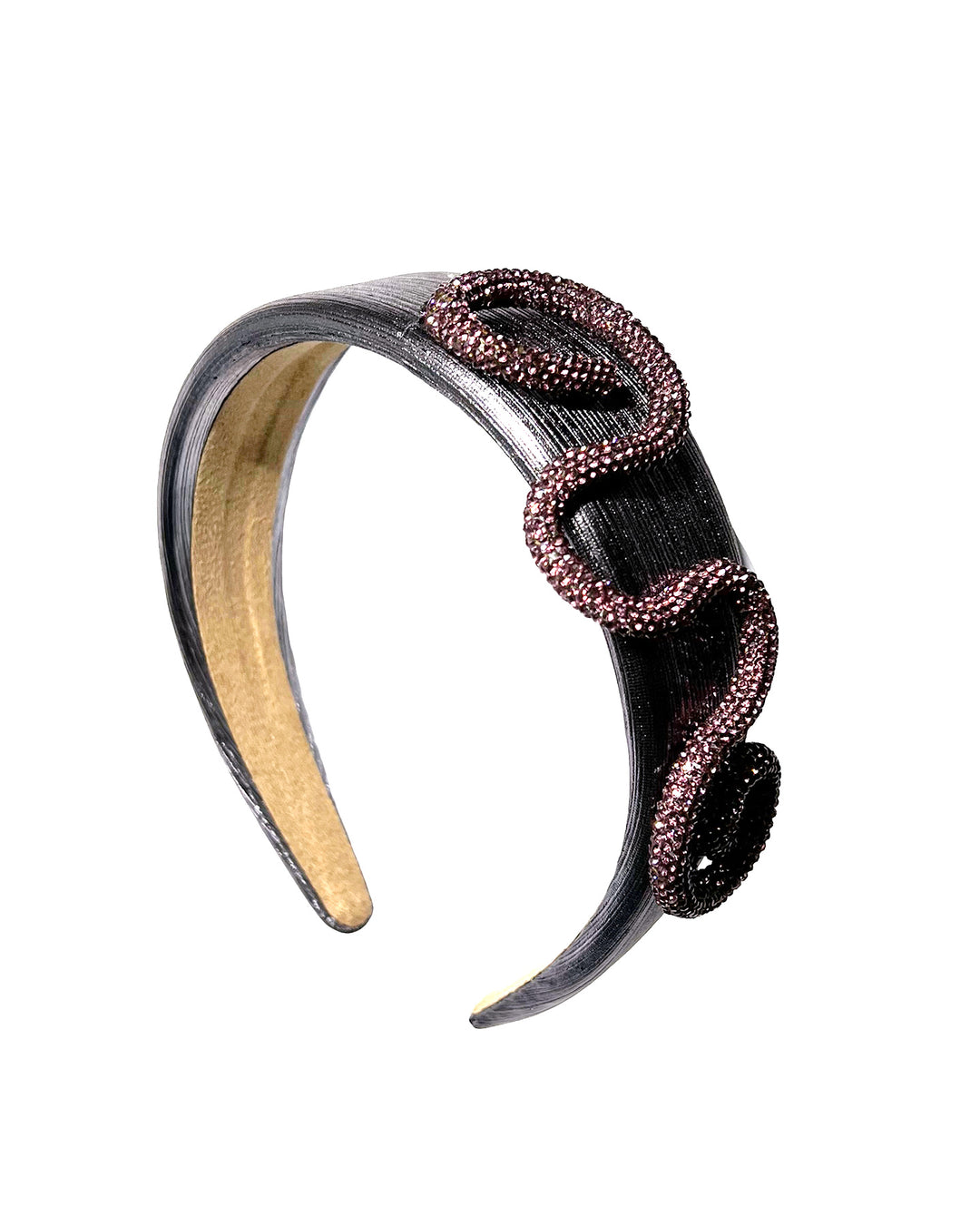 Charcoal silver headband with a wide faux leather base, adorned with a sculptural wave of rose-pink crystal-embellished cord looping across the top in an elegant, asymmetrical design. Designed and made by Merve Bayindir Millinery.
