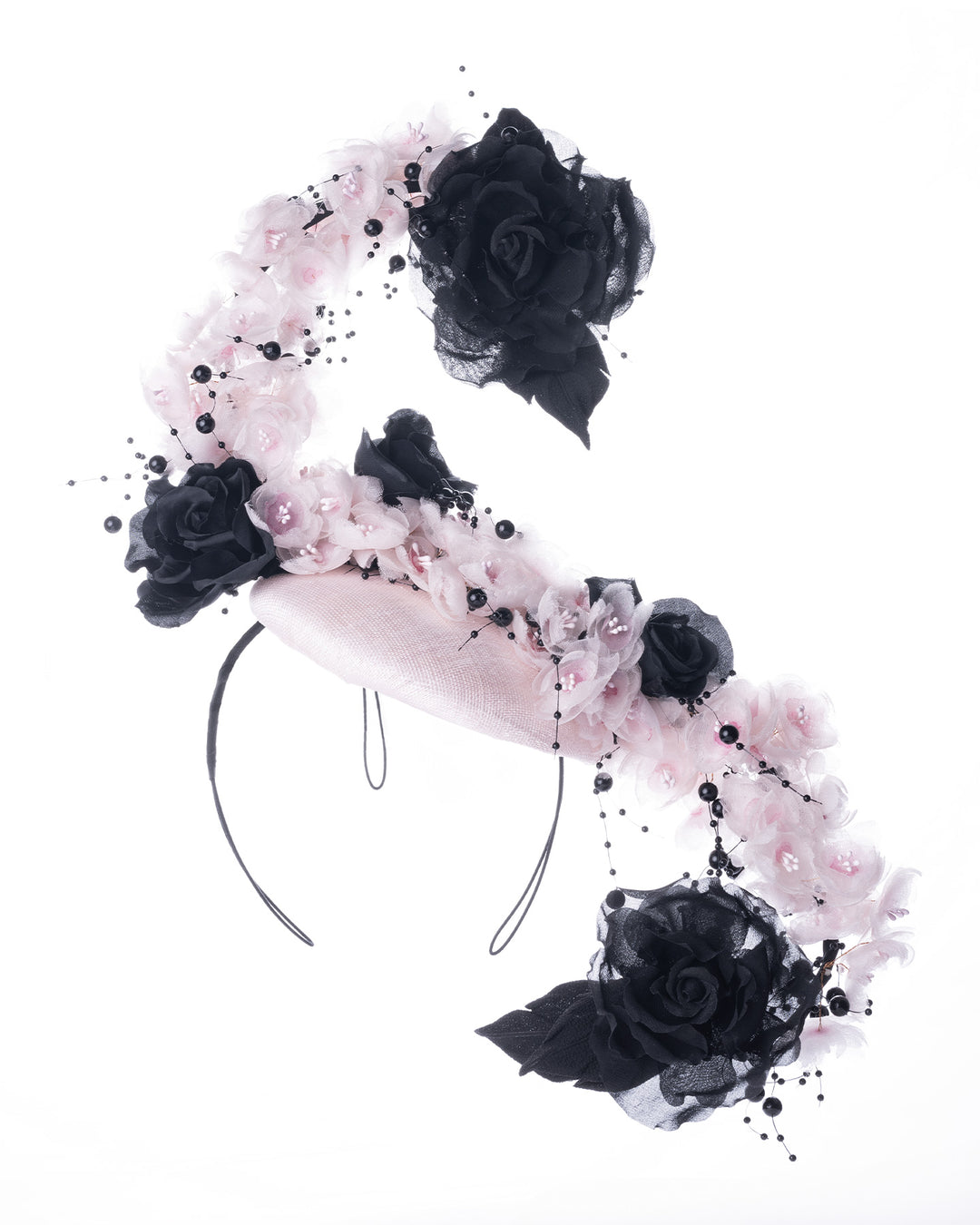 Blush pink oval fascinator adorned with cascading black and soft pink chiffon flowers, accented with delicate black bead sprays, creating a dramatic, sculptural statement design. Designed and made by Merve Bayindir Millinery.