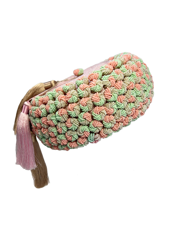 Crocheted clutch bag with pink and green pattern on a white background