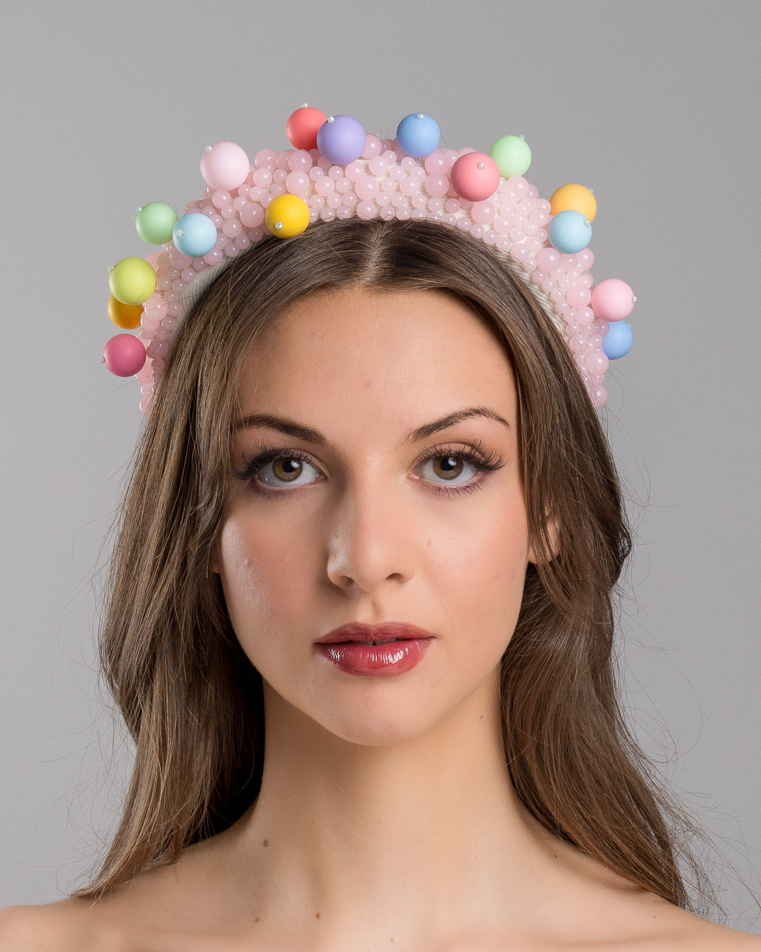 Model is showcasing front side close up multi size pink beaded headband adorned with large multi size mat bubble look a like multi colour multi size beads. Mde by Merve Bayindir.