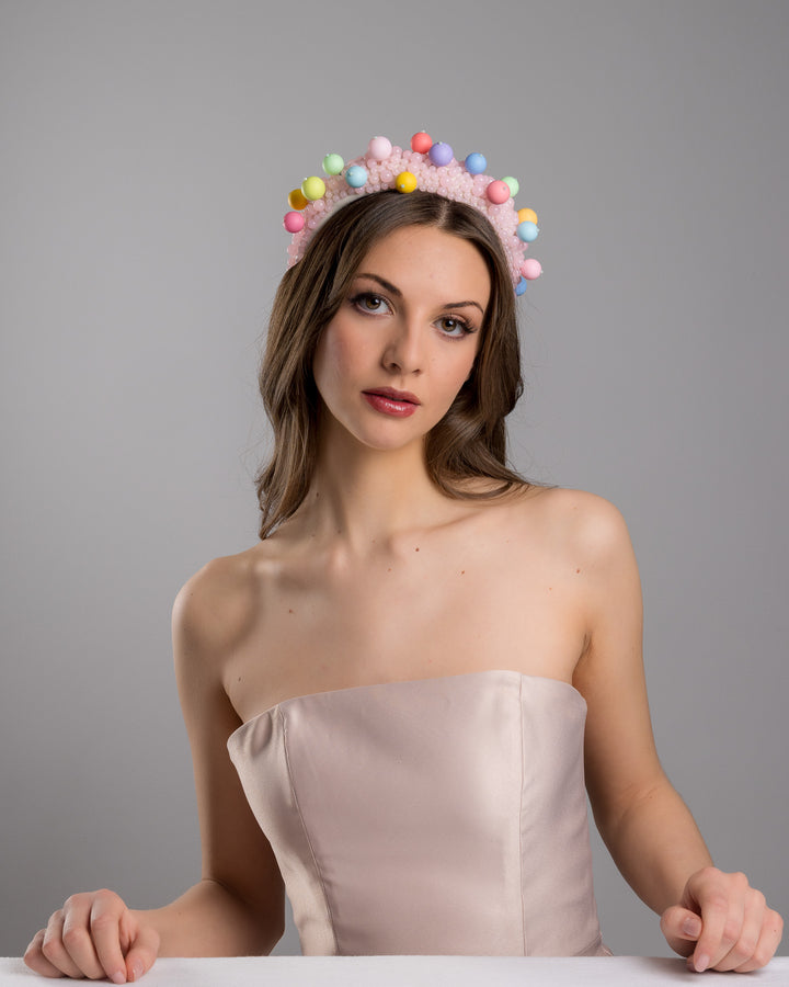 Female model posing wearing multi size pink beaded headband adorned with large multi size mat bubble look a like multi colour multi size beads. Mde by Merve Bayindir.