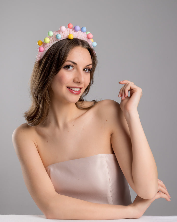 Female model posing wearing multi size pink beaded headband adorned with large multi size mat bubble look a like multi colour multi size beads. Mde by Merve Bayindir.