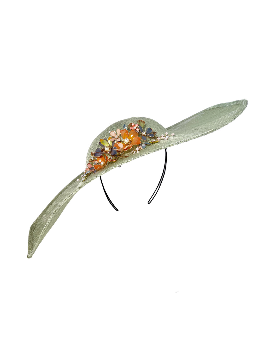 Green decorative hat with floral embellishments on a white background