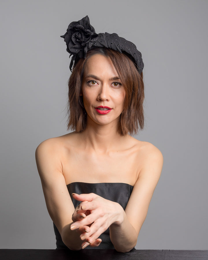 Female model is posing wearing Tango high lycra black headband, decorated with crepe rose and leafs embellished with crystals made by Merve Bayindir millinery.