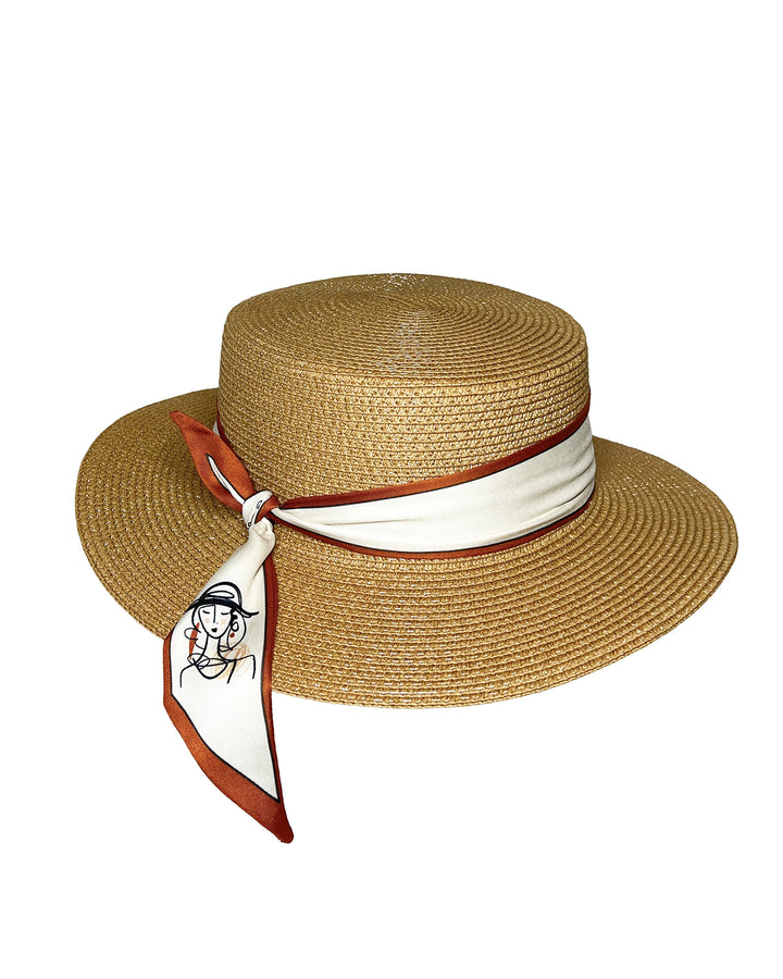 Natural woven straw boater hat with a wide brim, wrapped in a cream and rust silk ribbon and finished with a tied scarf featuring an illustrated female portrait detail. Design and made by Merve Bayindir millinery.