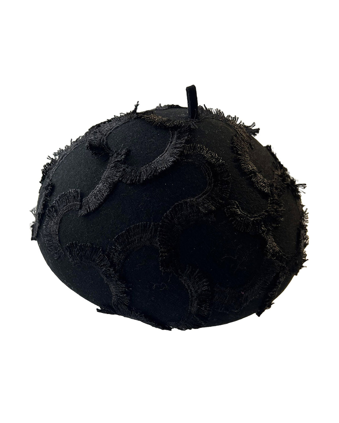 Still life picture of the Tilda pillbox beret hat. Made from structured black wool felt, the rounded dome-like silhouette is embroidered with a raised abstract motif in tonal thread, creating a sense of depth without distraction. Designed by Merve Bayindir.