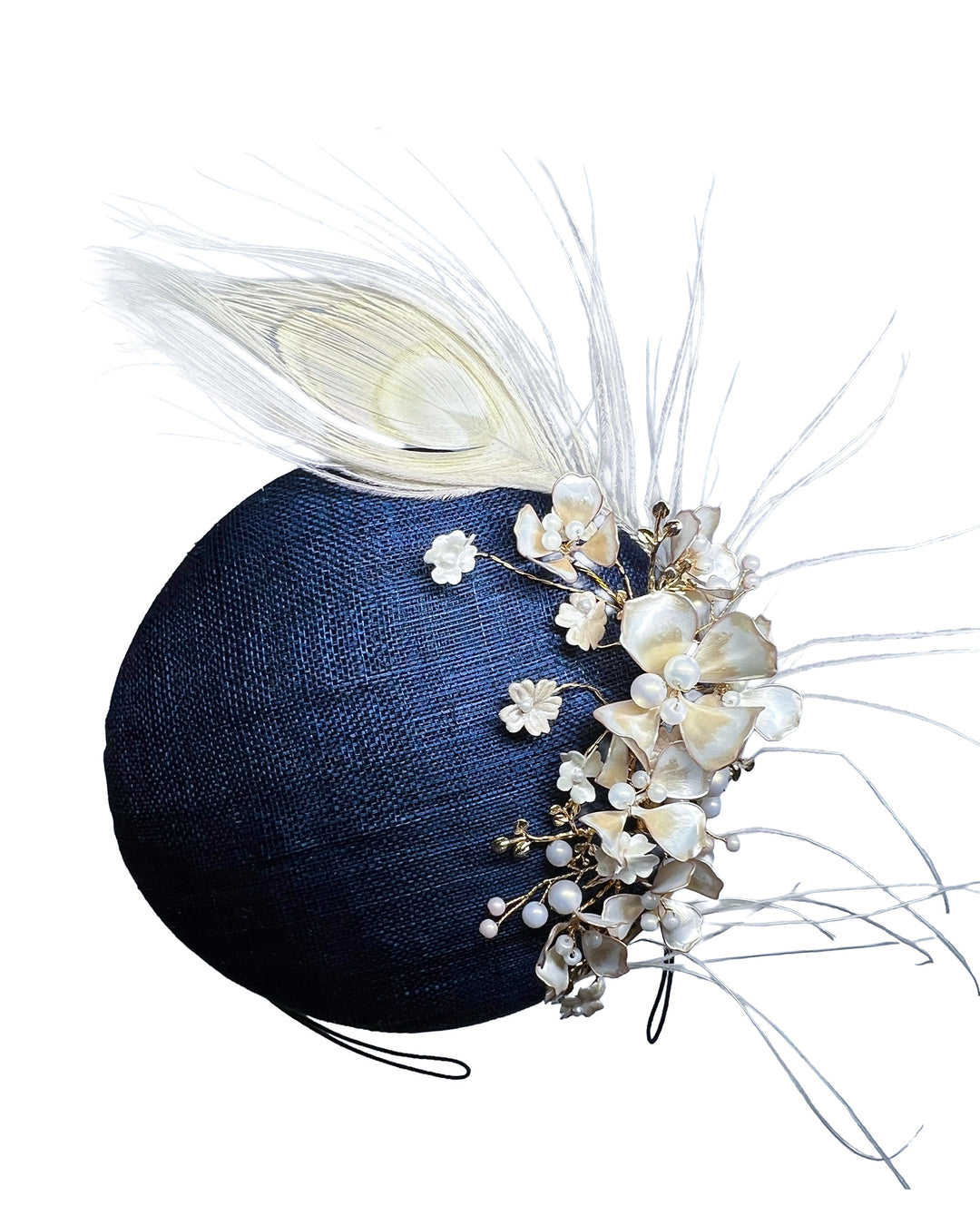 Navy blue sinamay fascinator with a smooth rounded base, adorned with ivory floral embellishments, pearl accents, delicate gold branches, and soft white feather detailing for an elegant, refined finish. Designed and made by Merve Bayindir Millinery

