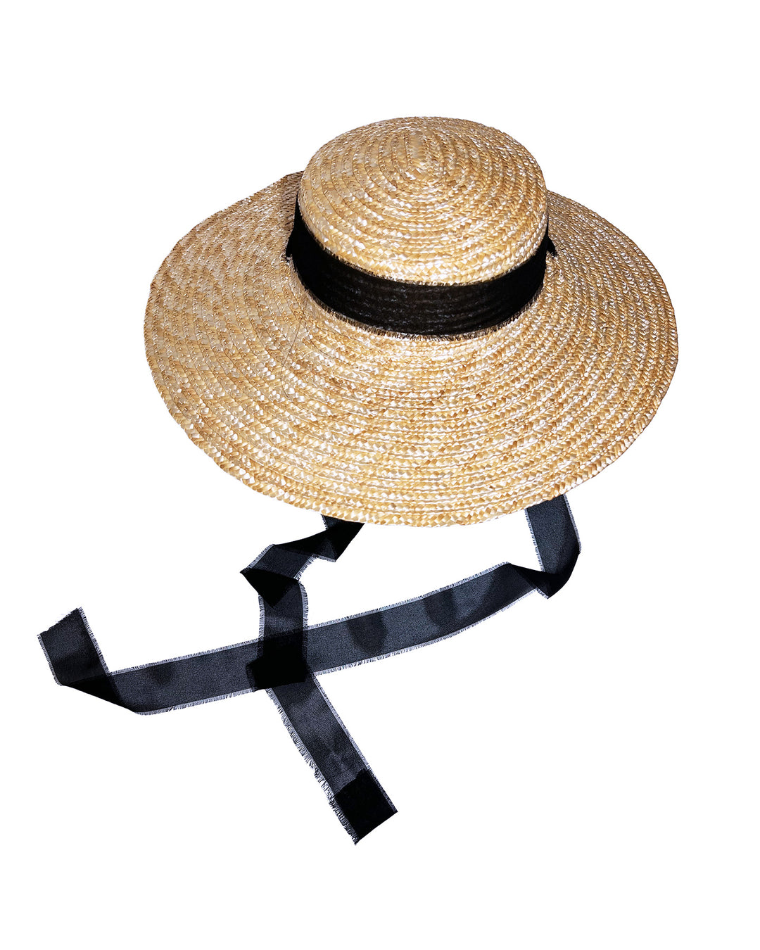 Natural woven straw boater hat with a wide brim, finished with a black ribbon band and long sheer black ties that extend from the back. Designed and made by Merve Bayindir millinery.